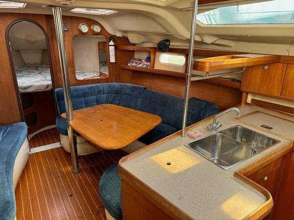 Slide: The Image of Interior of a 1996 Hunter 376 sailboat with cozy seating and compact kitchen area. - 4