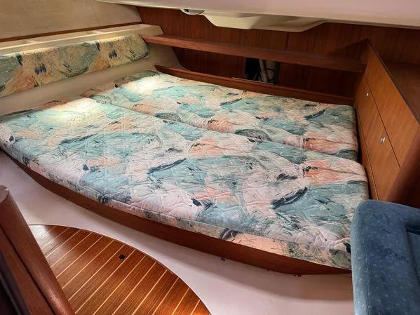 Slide: The Image of Interior cabin of a 1996 Hunter 376 sailboat with a patterned bed and wooden accents. - 5