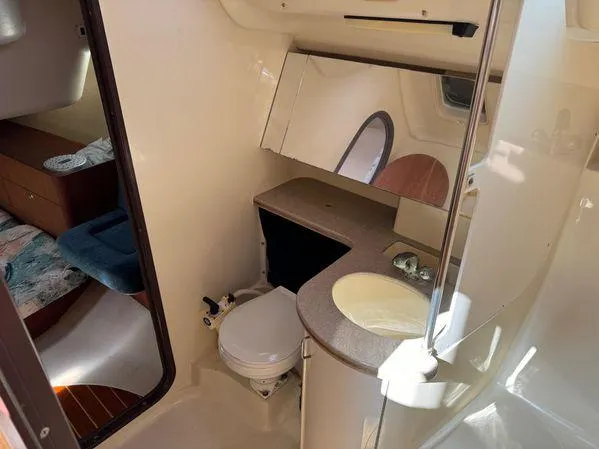 Slide: The Image of Bathroom interior of a 1996 Hunter 376 sailboat, featuring a sink, toilet, and mirror. - 6