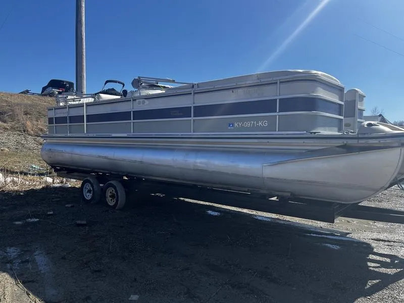 The Image of 2001 Harris FLOTE-BOTE 26 pontoon boat on trailer, parked outdoors. - 1