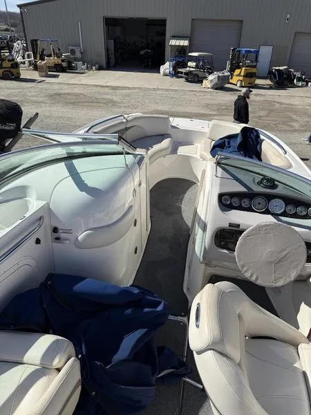 Slide: The Image of 2005 Chaparral SUNSESTA boat interior with seating and dashboard, parked in a marina. - 3
