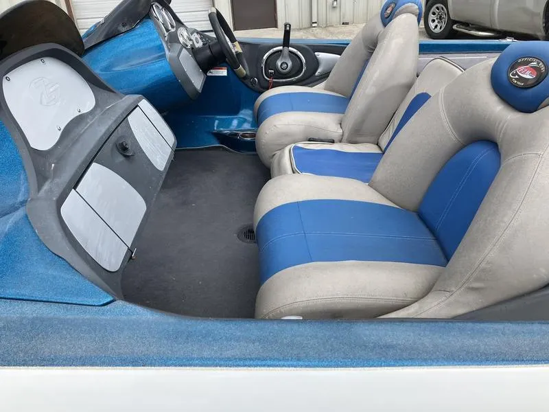 Slide: The Image of 2006 Ranger Z21 boat interior with blue and gray seating, steering wheel, and dashboard. - 3