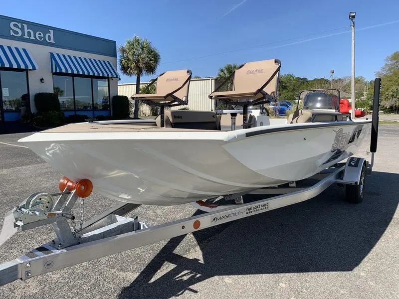 Slide: The Image of 2025 SeaArk Easy 200 boat on trailer, parked outside a building with blue-striped awnings. - 7