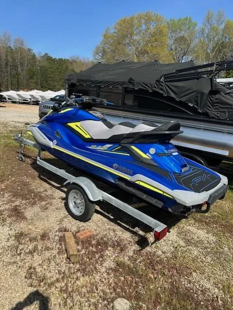 Slide: The Image of 2020 Yamaha WaveRunner FX Cruiser SVHO on trailer, blue and yellow design, parked outdoors. - 3