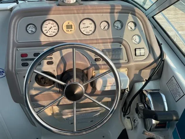 Slide: The Image of 1994 Rinker Fiesta Vee 265 boat dashboard with steering wheel and gauges. - 10