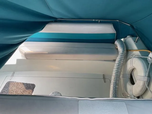 Slide: The Image of 1994 Rinker Fiesta Vee 265 boat interior with blue canopy and seating area. - 12