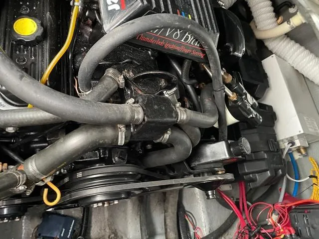 Slide: The Image of Engine compartment of a 1994 Rinker Fiesta Vee 265 boat, showcasing hoses and components. - 14