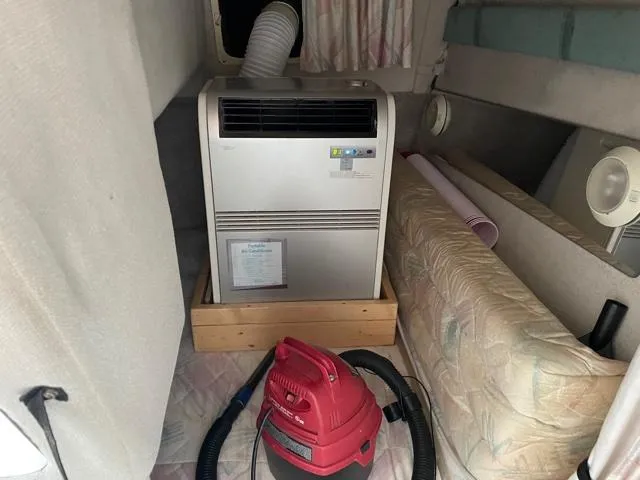 Slide: The Image of 1994 Rinker Fiesta Vee 265 cabin with portable air conditioner and vacuum cleaner. - 20