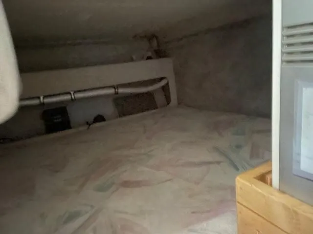 Slide: The Image of Interior cabin of 1994 Rinker Fiesta Vee 265 boat, featuring a cozy sleeping area. - 21