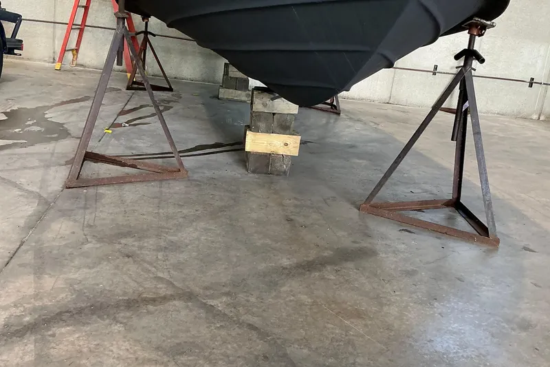 Slide: The Image of 1994 Rinker Fiesta Vee 265 boat hull supported by stands in a garage. - 25