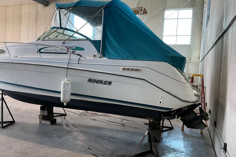 Slide: The Image of 1994 Rinker Fiesta Vee 265 boat in storage with blue cover. - 26