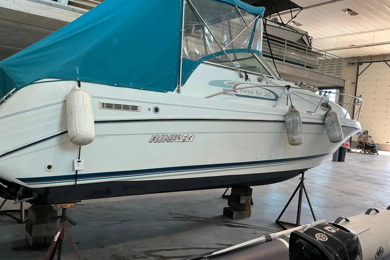 Slide: The Image of 1994 Rinker Fiesta Vee 265 boat in storage, covered with a blue canopy. - 28