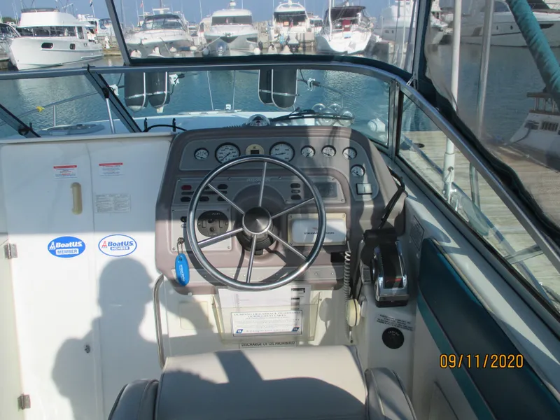 Slide: The Image of 1994 Rinker Fiesta Vee 265 boat cockpit with steering wheel and control panel. - 3