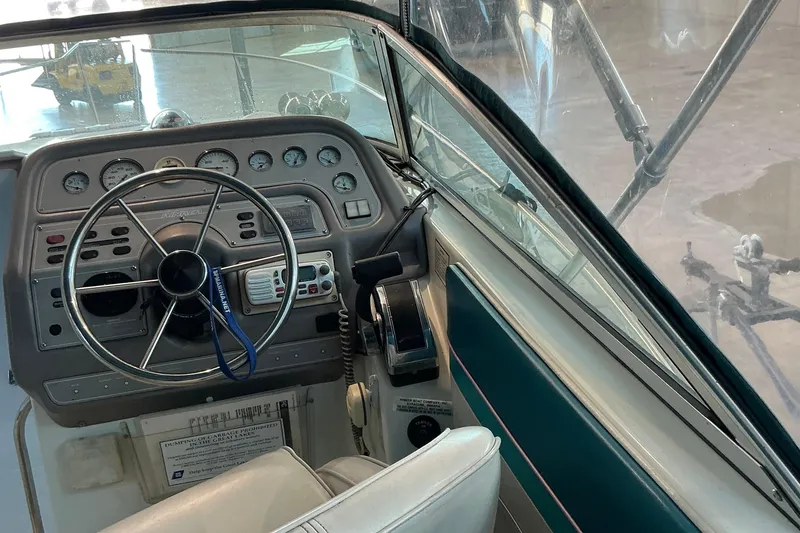 Slide: The Image of 1994 Rinker Fiesta Vee 265 boat cockpit with steering wheel and control panel. - 30