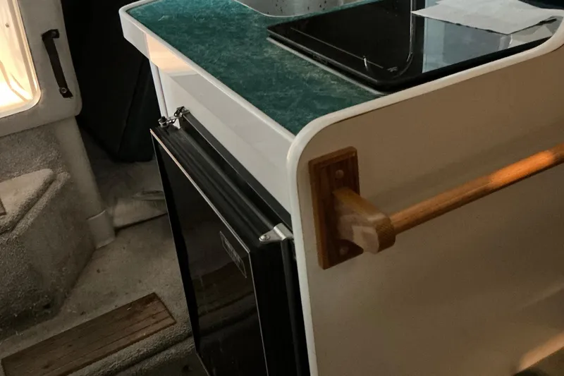 Slide: The Image of Interior of 1994 Rinker Fiesta Vee 265 boat with kitchenette and wooden rail. - 39