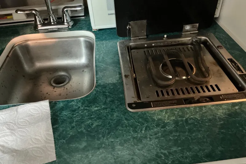 Slide: The Image of 1994 Rinker Fiesta Vee 265 kitchen with sink and stove on green countertop. - 41