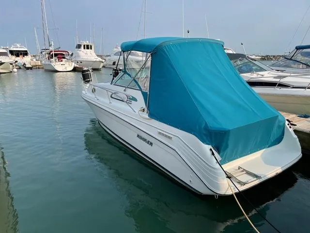 Slide: The Image of 1994 Rinker Fiesta Vee 265 boat docked in marina with blue canopy. - 7