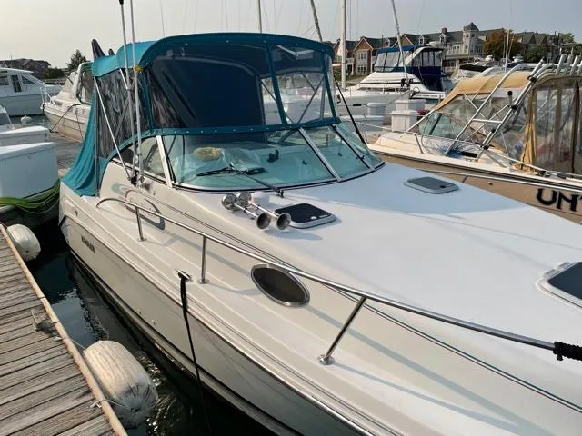 Slide: The Image of 1994 Rinker Fiesta Vee 265 boat docked at marina with blue canopy. - 8