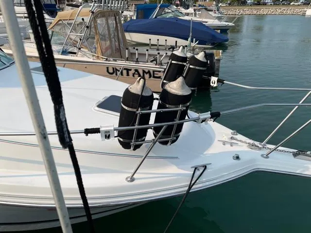 Slide: The Image of 1994 Rinker Fiesta Vee 265 boat docked with fenders, marina background. - 9