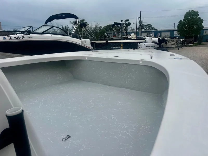 Slide: The Image of 2015 Blazer Bay 2220 GTS boat, white interior, docked with other boats in the background. - 5