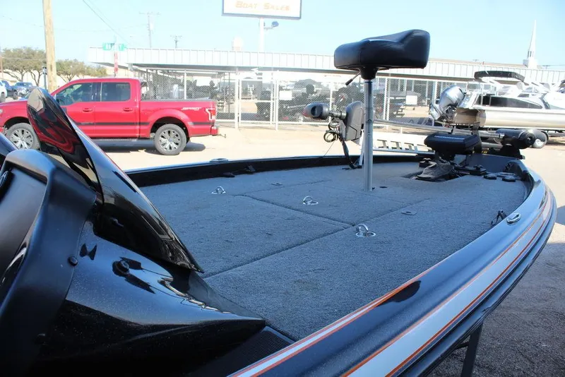 Slide: The Image of 2018 Phoenix 721 ProXP boat deck with seating and equipment, parked near a red truck. - 13