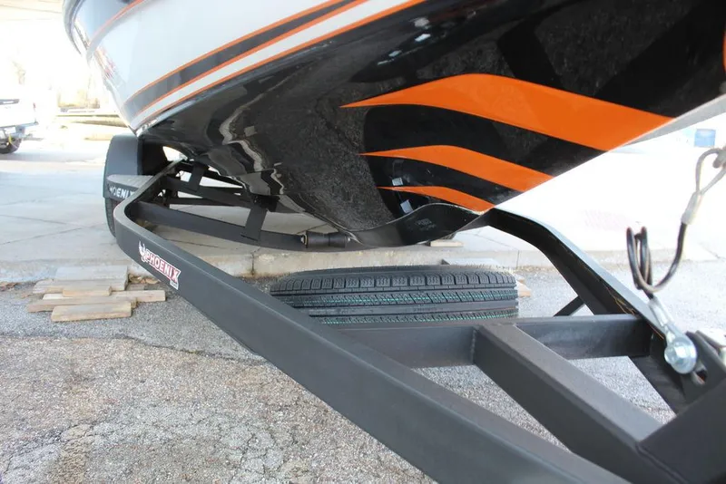 Slide: The Image of 2018 Phoenix 721 ProXP boat on trailer, featuring sleek black and orange design. - 16