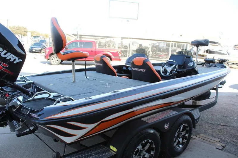 Slide: The Image of 2018 Phoenix 721 ProXP bass boat with orange accents and dual seats on a trailer. - 9