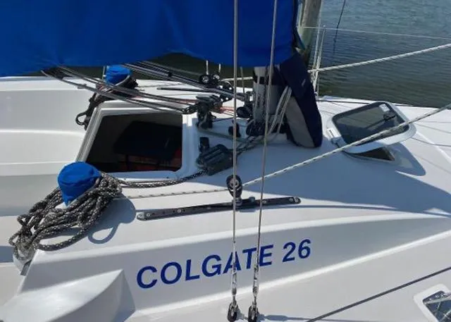 Slide: The Image of Sailboat Colgate 26, 2013 model, docked with visible ropes and open hatch. - 3