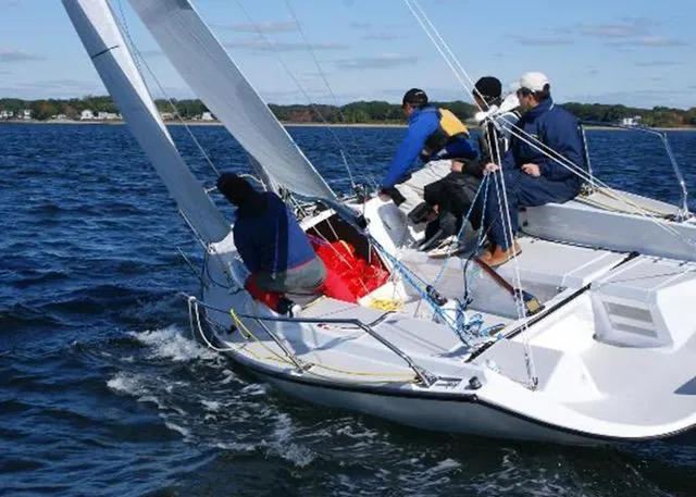 Slide: The Image of Sailors navigating a 2013 Colgate Sloop on open water. - 7