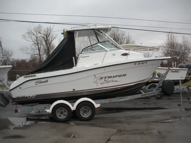 Slide: The Image of 2004 Seaswirl Striper 2101 Walkaround I/O boat on trailer, parked outdoors. - 0