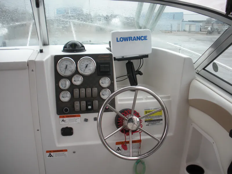 Slide: The Image of 2004 Seaswirl Striper 2101 Walkaround I/O dashboard with steering wheel and Lowrance navigation system. - 8