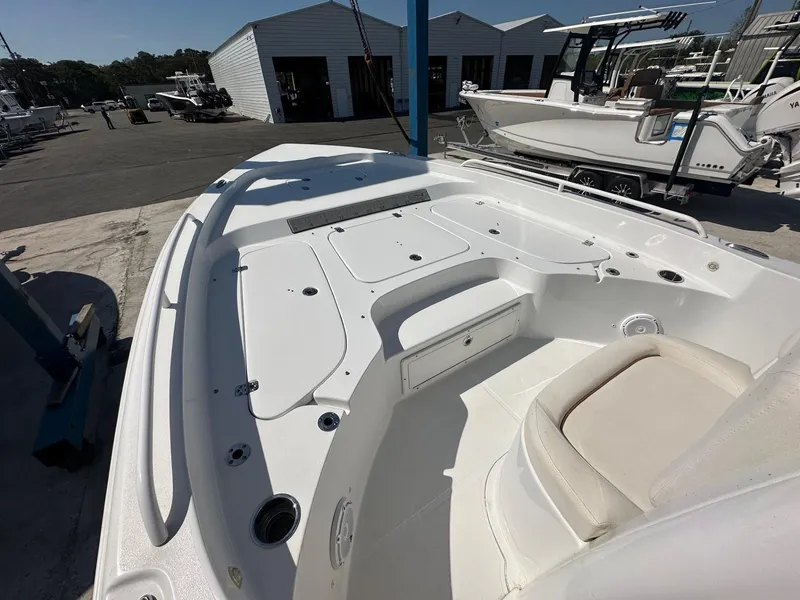 Slide: The Image of 2022 Sea Hunt BX 25 FS boat interior at a marina, showcasing seating and storage. - 10