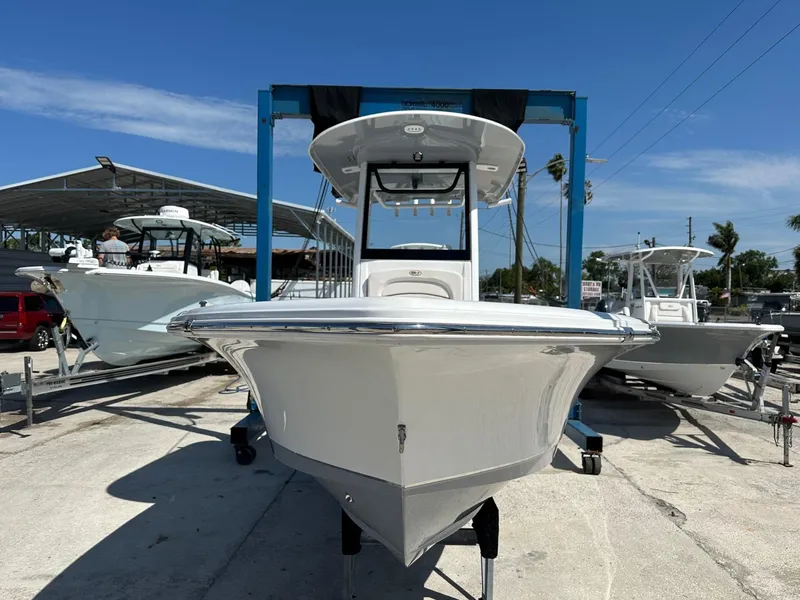 Slide: The Image of 2022 Sea Hunt BX 25 FS boat on display at a marina under clear blue skies. - 4