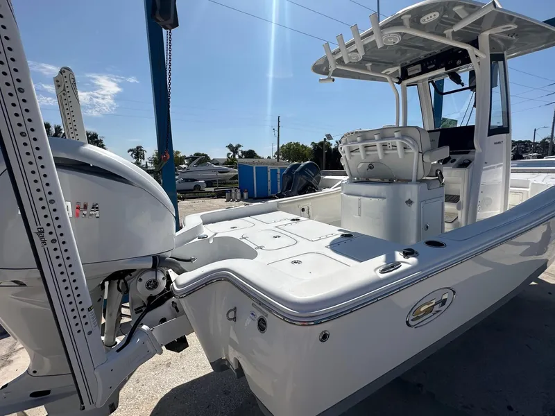 Slide: The Image of 2022 Sea Hunt BX 25 FS boat with outboard motor, docked under clear sky. - 6