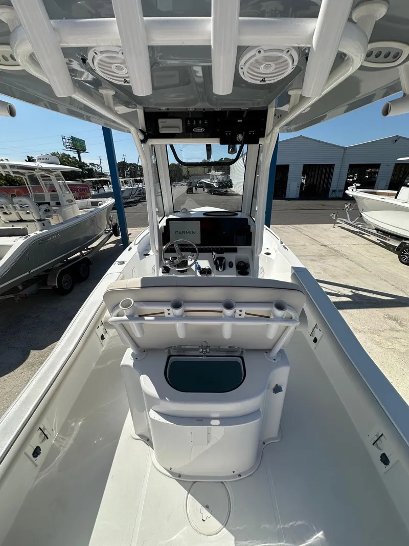 Slide: The Image of 2022 Sea Hunt BX 25 FS boat interior with console and seating, docked at a marina. - 8