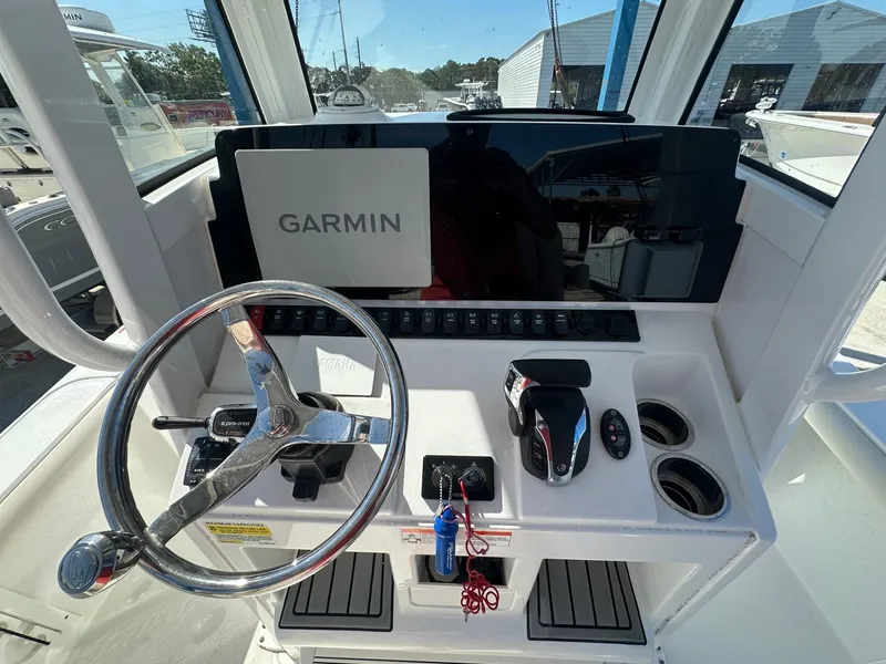 Slide: The Image of 2022 Sea Hunt BX 25 FS boat console with Garmin navigation system and steering wheel. - 9