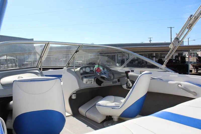 Slide: The Image of 2007 Bayliner 185 BR boat interior with blue and white seating, steering wheel, and dashboard. - 12