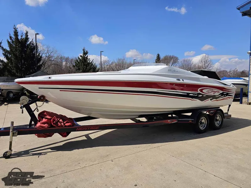 Slide: The Image of 2008 Baja 23 Outlaw speedboat on trailer, red and white design, parked outdoors. - 15