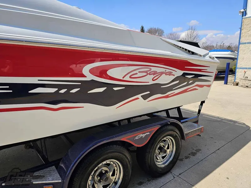 Slide: The Image of 2008 Baja 23 Outlaw boat with red and black graphics on a trailer. - 23
