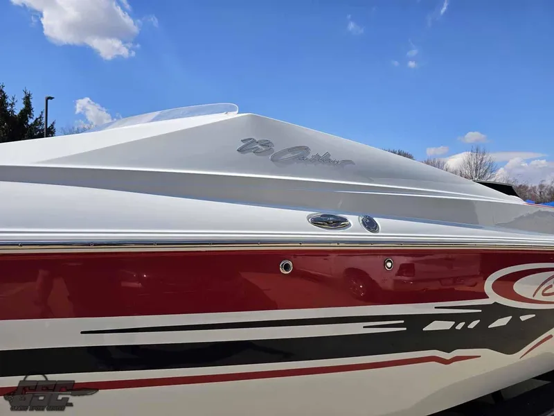 Slide: The Image of 2008 Baja 23 Outlaw boat with red and white design under a clear blue sky. - 25