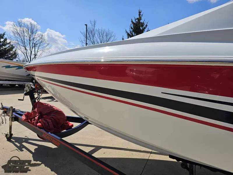 Slide: The Image of 2008 Baja 23 Outlaw boat with red and black stripes on a trailer. - 26