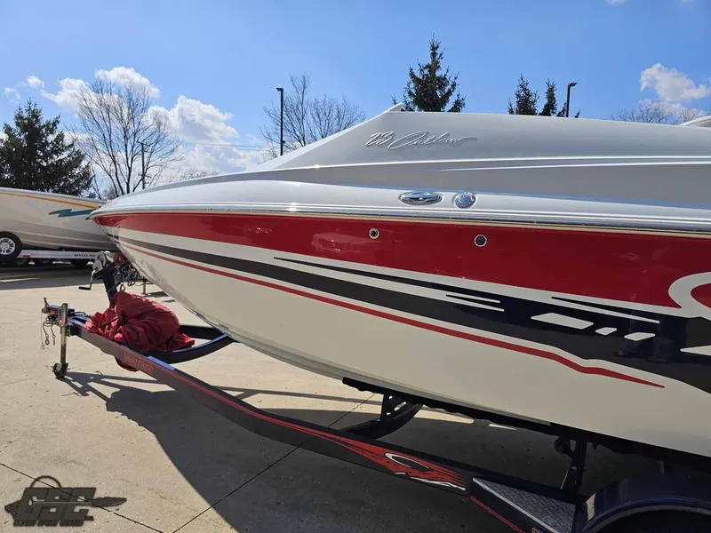 Slide: The Image of 2008 Baja 23 Outlaw boat with red and white design on a trailer. - 27