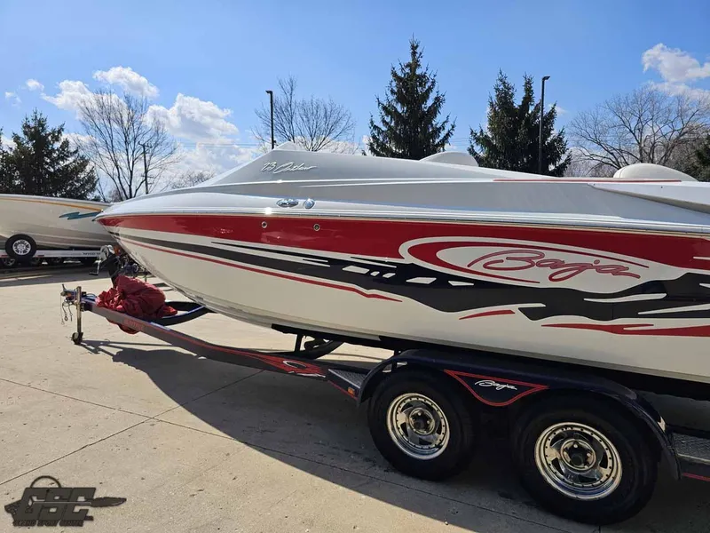 Slide: The Image of 2008 Baja 23 Outlaw boat on trailer, red and white design, parked outdoors. - 28