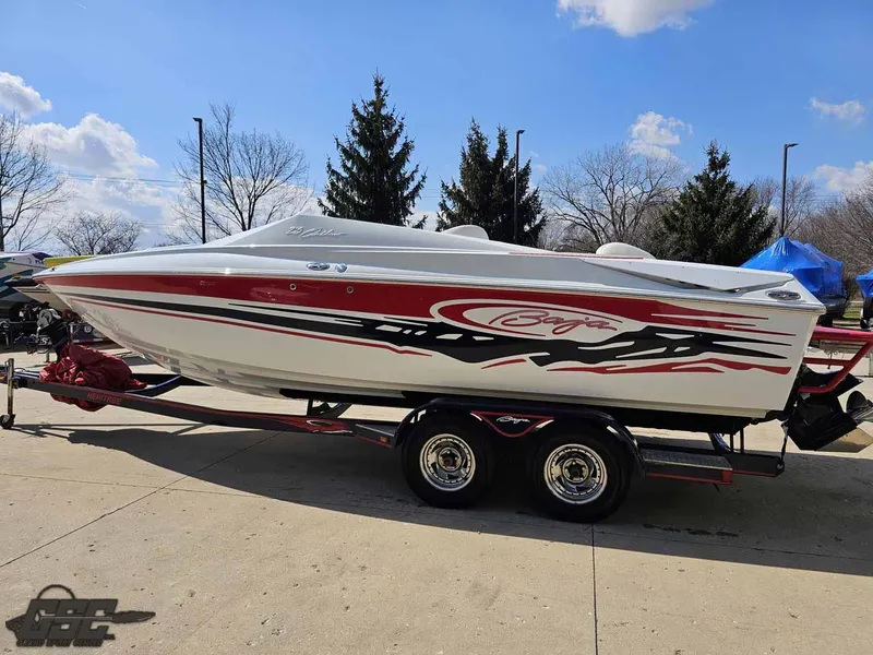 Slide: The Image of 2008 Baja 23 Outlaw boat with red and black graphics on a trailer, parked outdoors. - 29