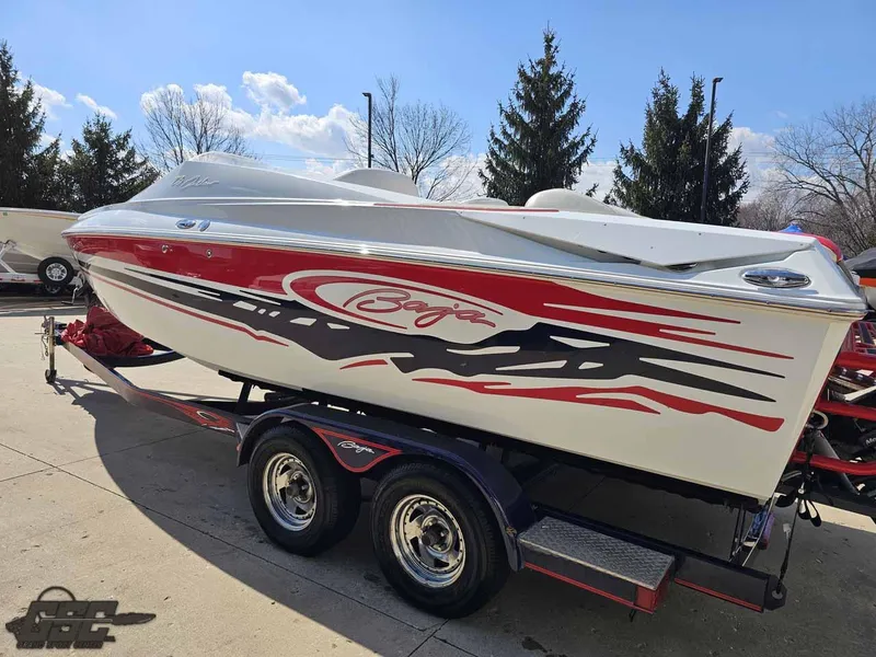 Slide: The Image of 2008 Baja 23 Outlaw speedboat with red and black graphics on a trailer. - 30