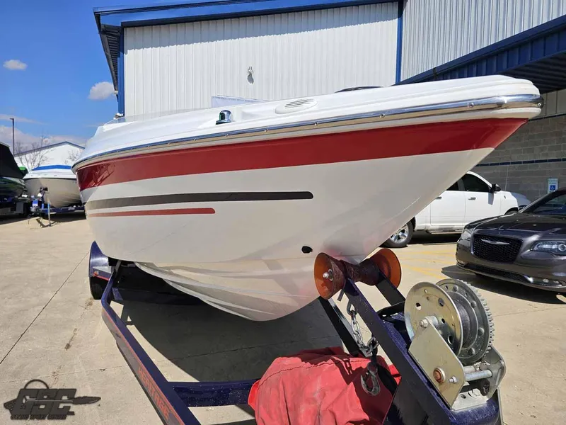Slide: The Image of 2008 Baja 23 Outlaw boat on trailer, red and white design, parked outdoors. - 31