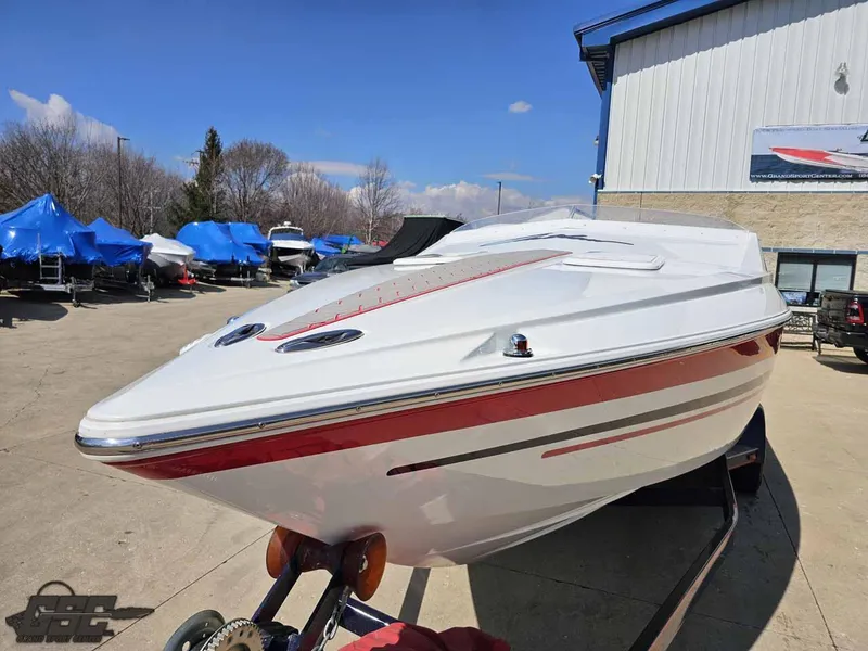 Slide: The Image of 2008 Baja 23 Outlaw speedboat with red accents on a trailer, outdoor setting. - 33