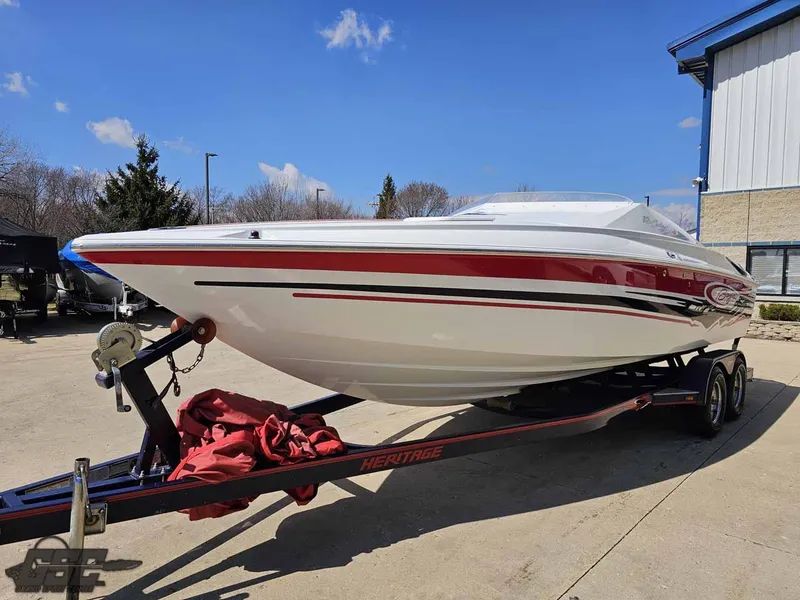 Slide: The Image of 2008 Baja 23 Outlaw speedboat on trailer, white with red accents, parked outdoors. - 34
