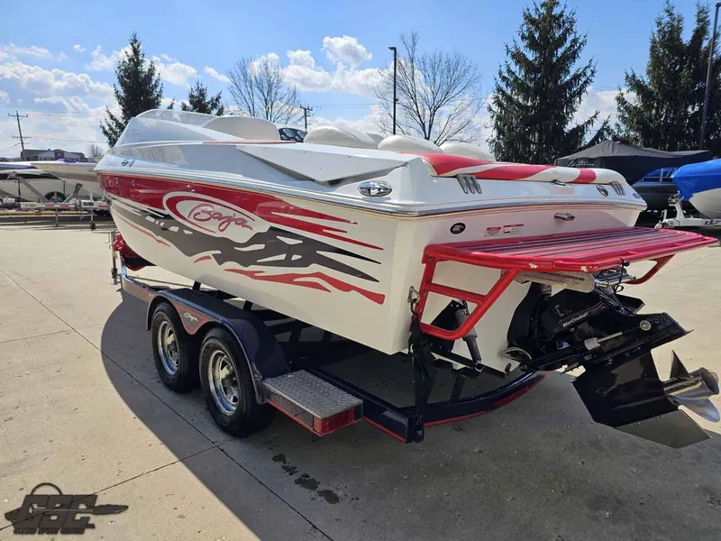 Slide: The Image of 2008 Baja 23 Outlaw boat on trailer, red and white design, parked outdoors. - 35