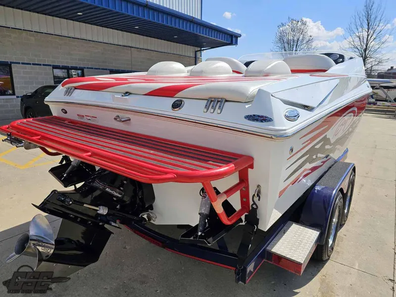 Slide: The Image of 2008 Baja 23 Outlaw boat with red accents on a trailer, parked outdoors. - 39